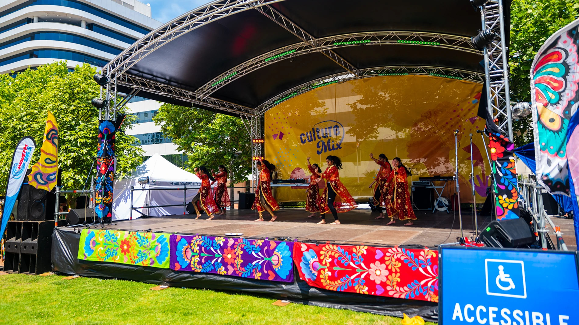 Capturing The Vibrancy Of Culture Mix: A Day Behind The Lens 1 Dancers Perform On Outdoor Stage With &Quot;Culture Mix&Quot; Banner, Accessibility Sign, Urban Backdrop.