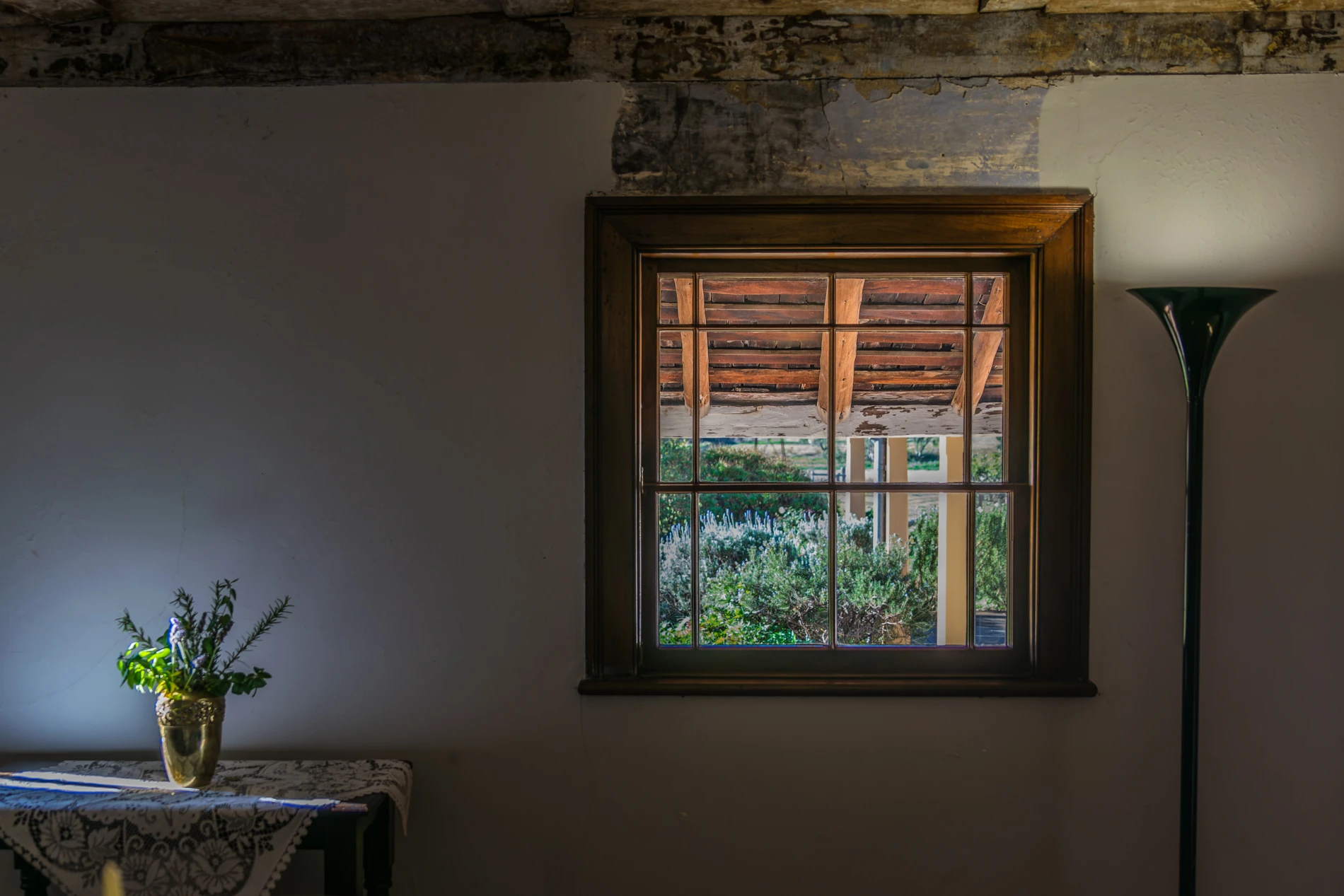 Indoor Scene With Wooden Window, Table With Vase On Cloth, And A Floor Lamp. Garden View Outside.