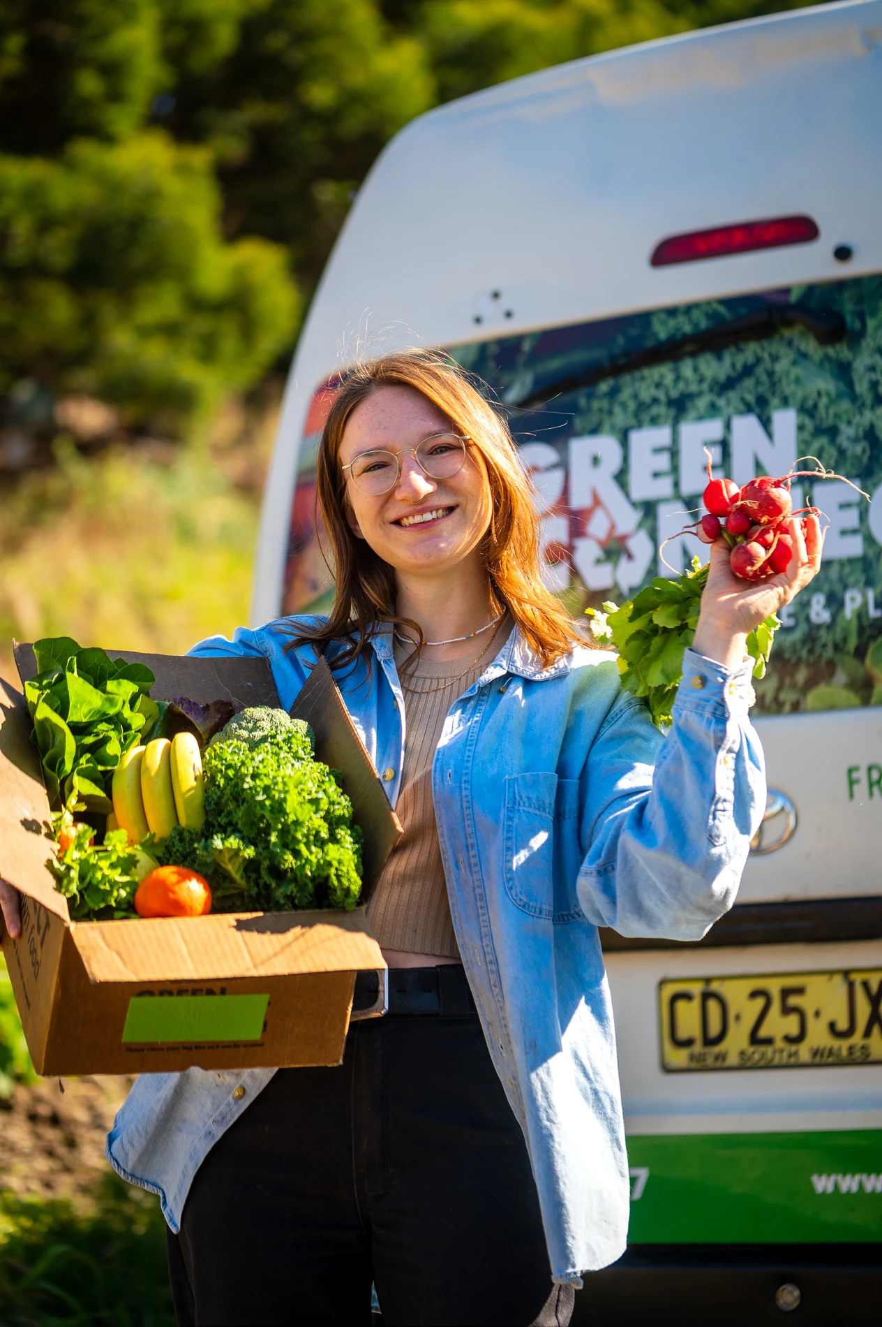 Post Green Connect Girl Holding Fruit Box In Front Of Van