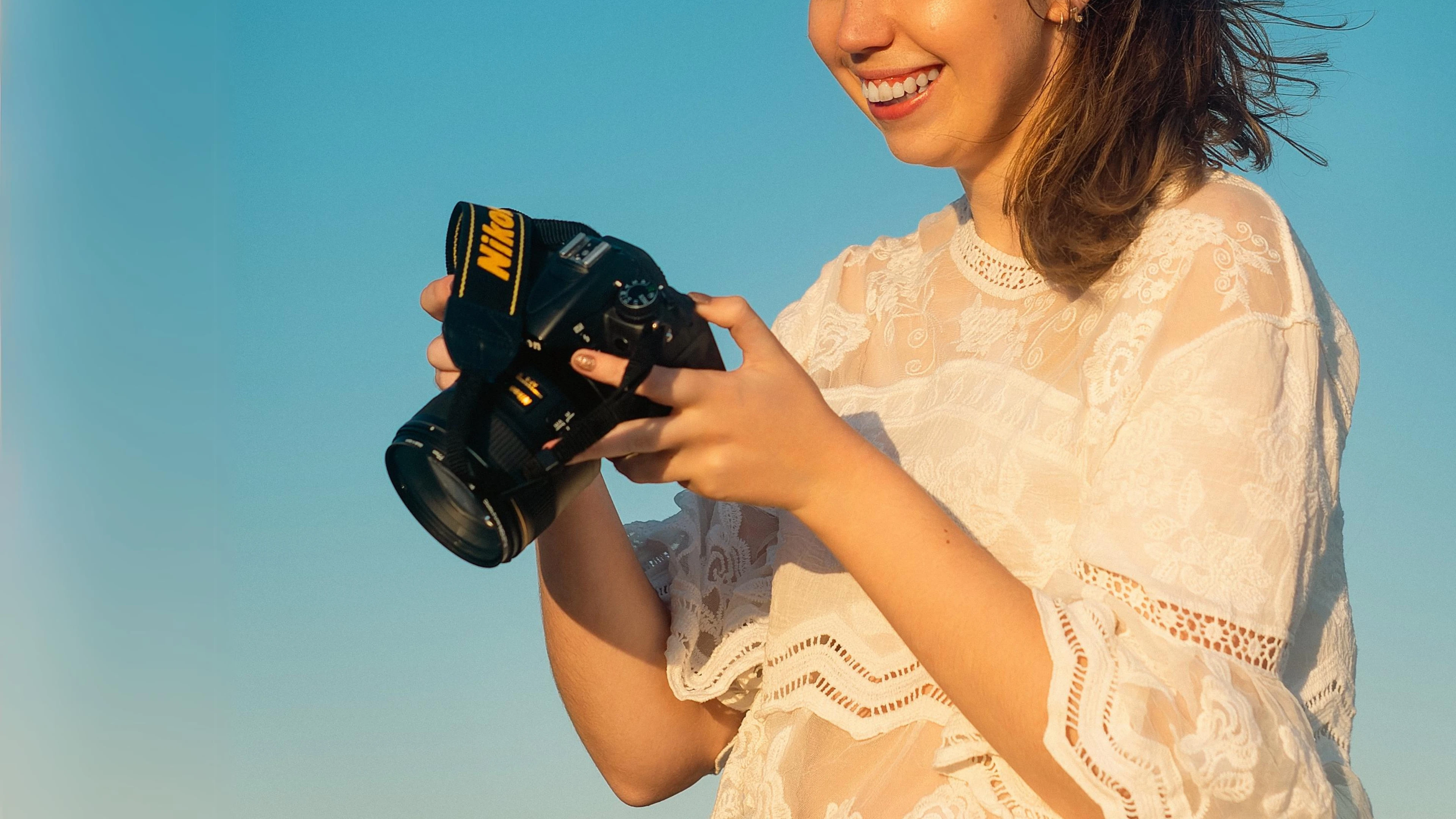2024 Photography Trends: Highresolution, Hyperrealism, And More 6 Person In Lace Top Holding Nikon Camera, Clear Blue Sky Background.