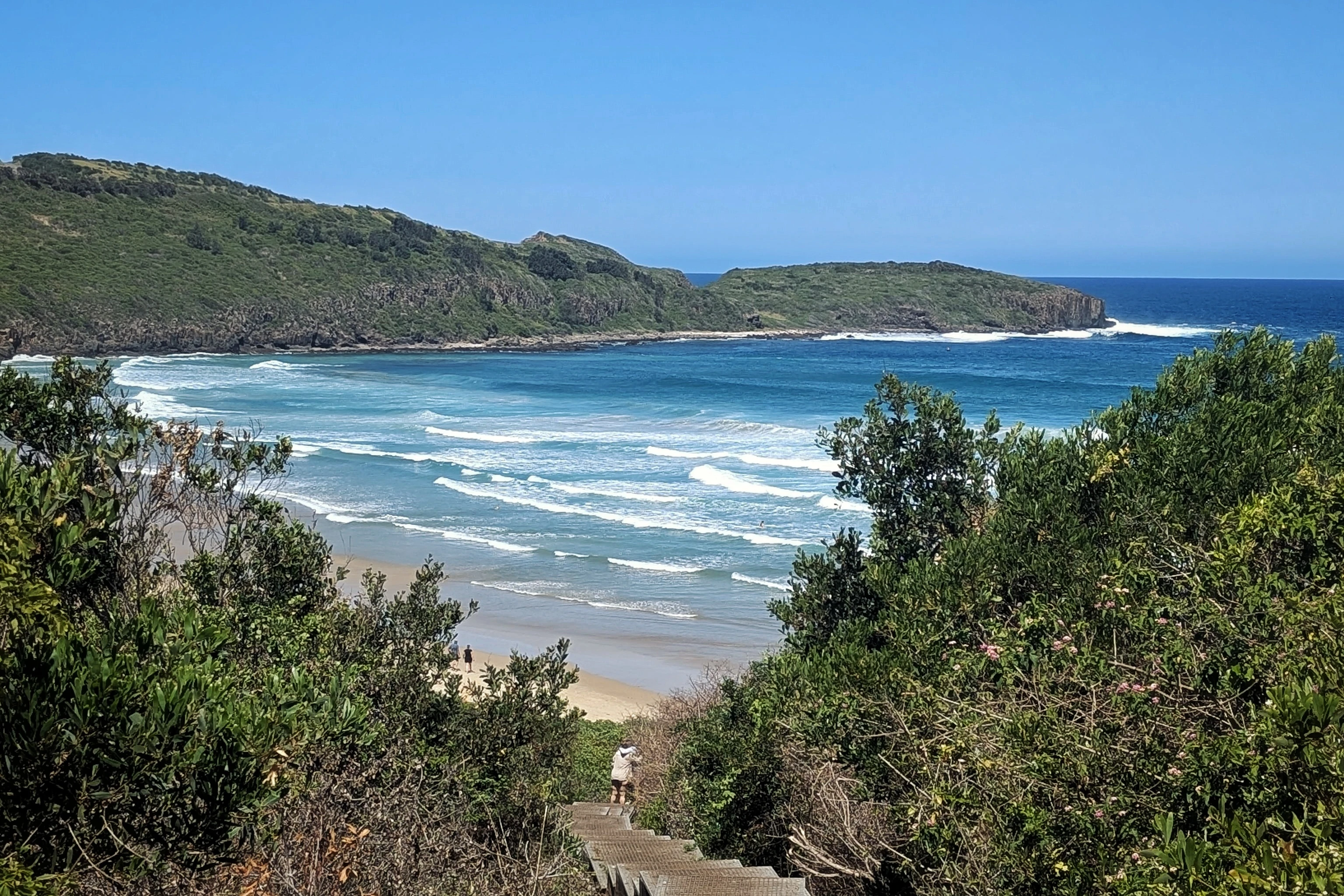 Neesh Photography In 2025: Ideas &Amp; Goals For The New Year 5 Beach Scene With Waves, Lush Hills, Wooden Staircase, Dense Vegetation, And Clear Blue Sky.