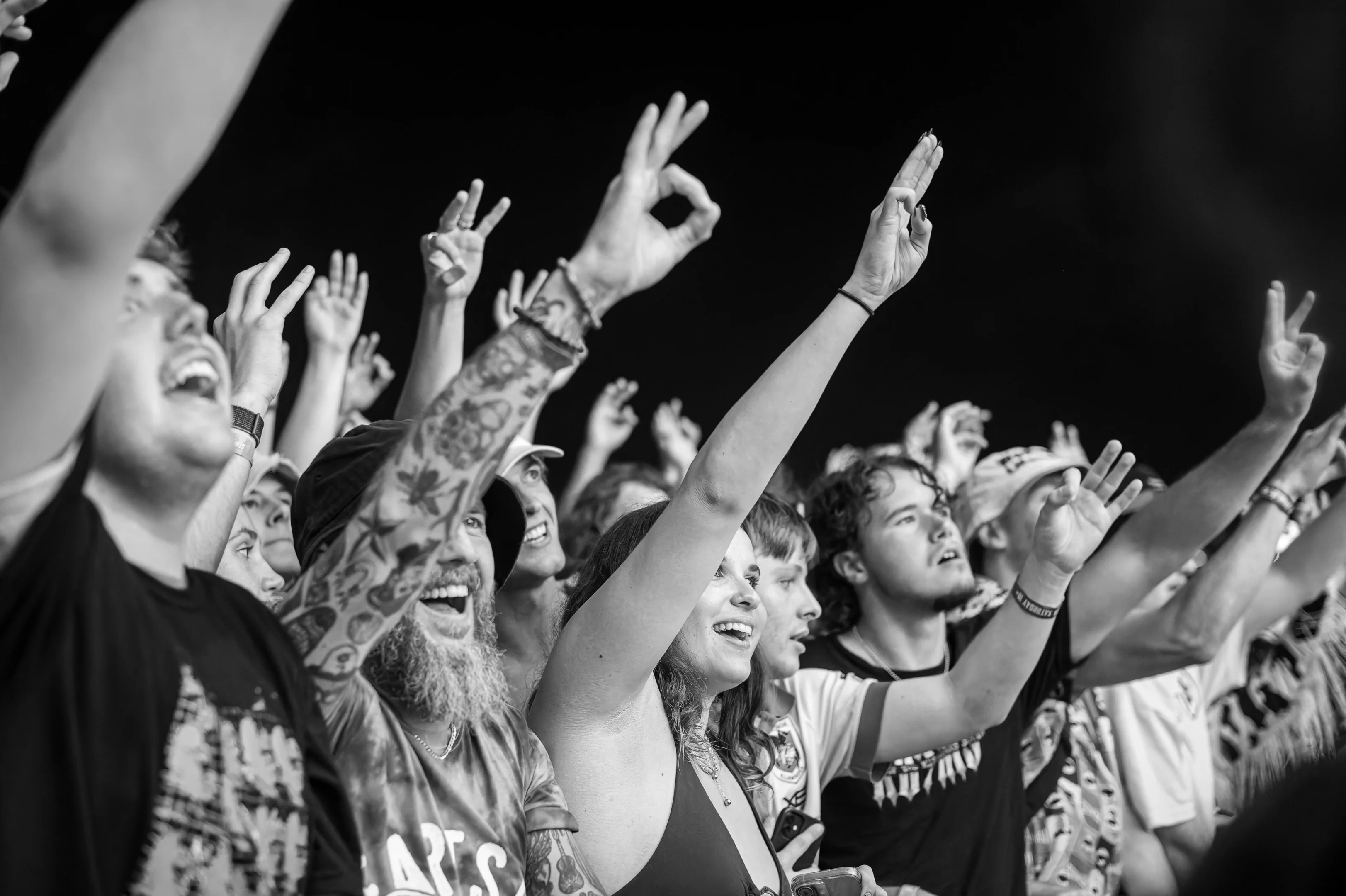 People In Black And White Photo At A Concert Raising Hands With Enthusiasm.